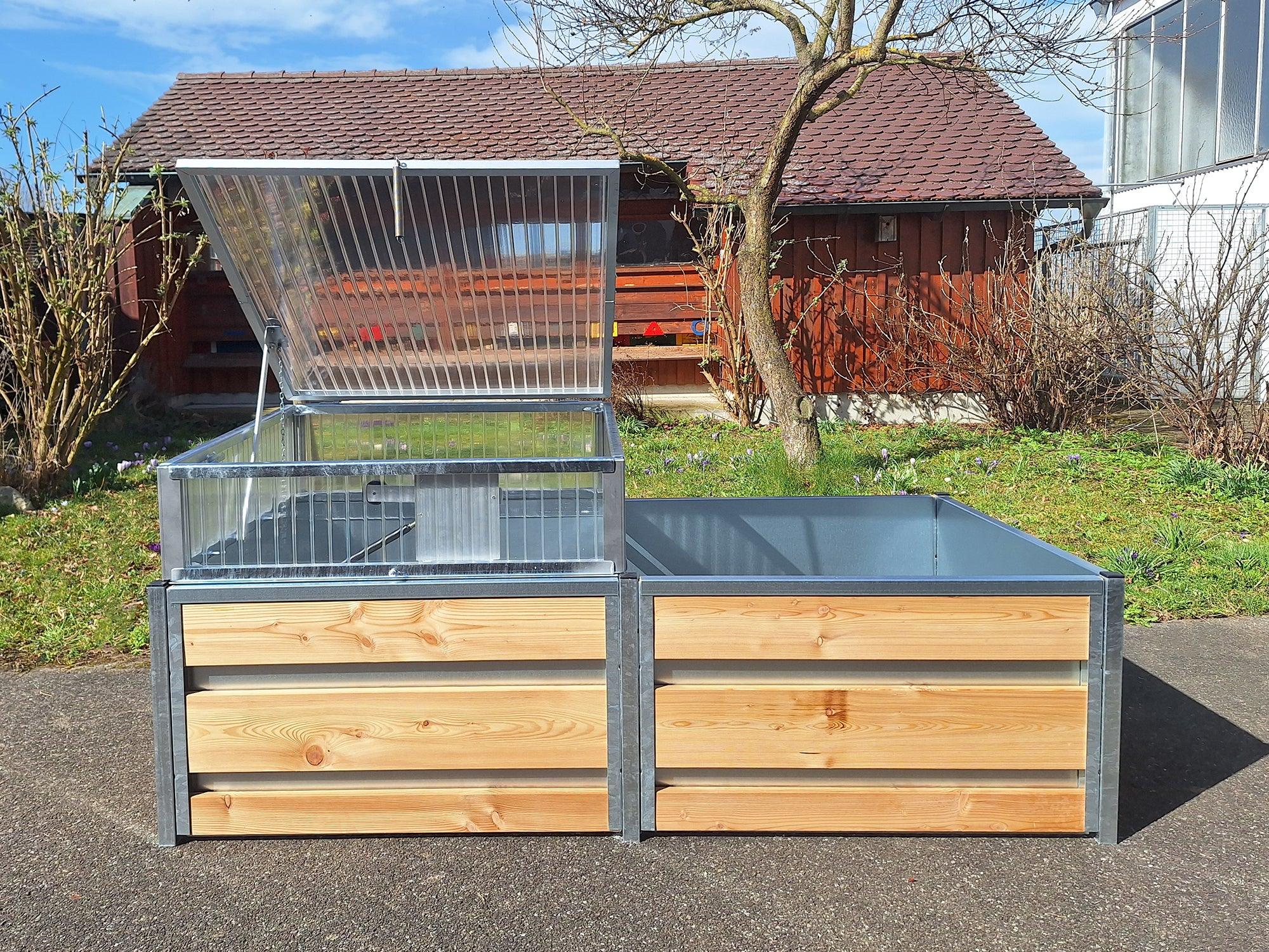 Geöffneter Frühbeetaufsatz aufgestellt in einem Hochbeet