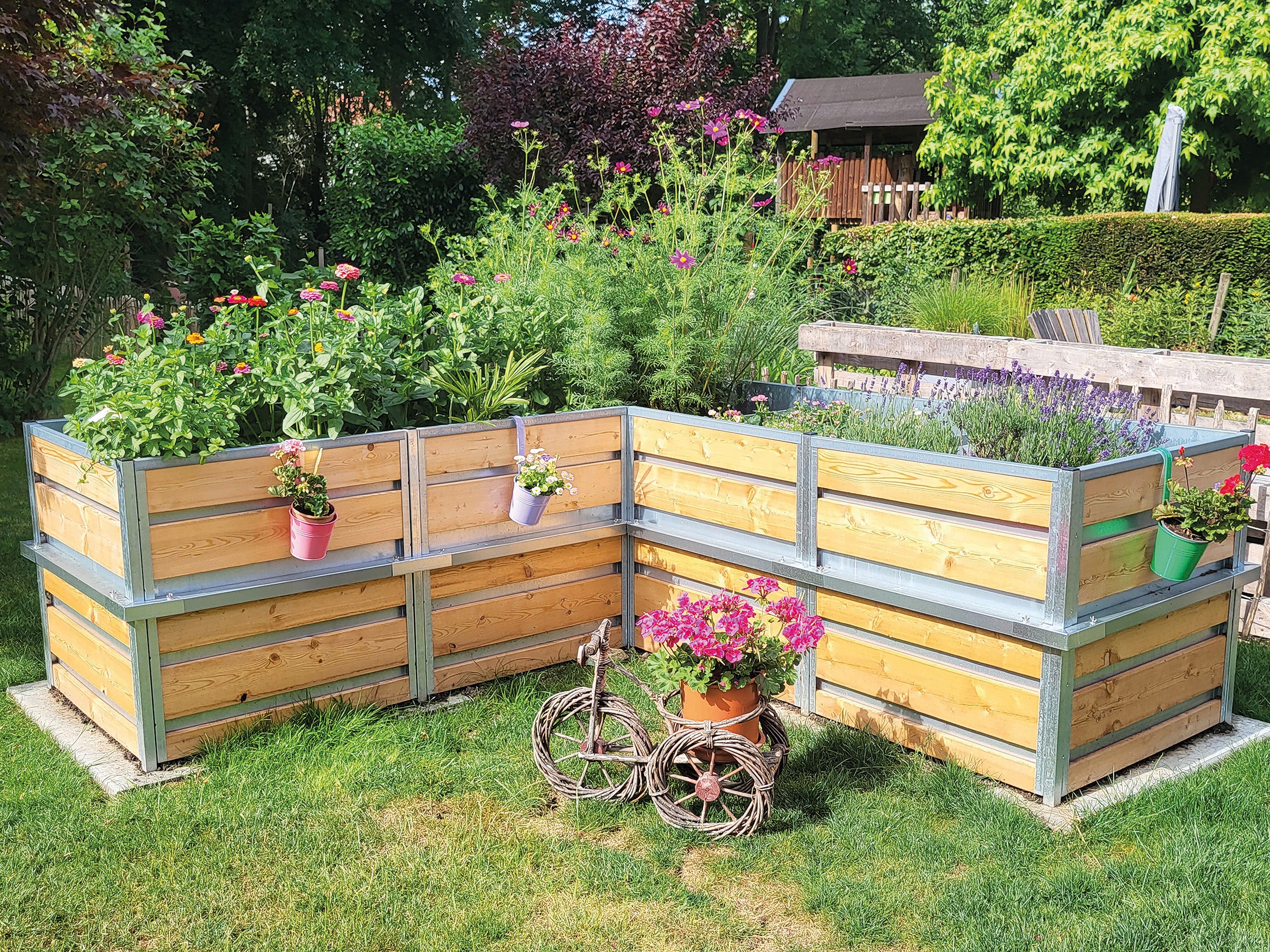 Kundenbild Hochbeet in L-Form. Mit der Eckbauweise fügt das Hochbeet aus Holz sich als Augenfang in den Garten  einein