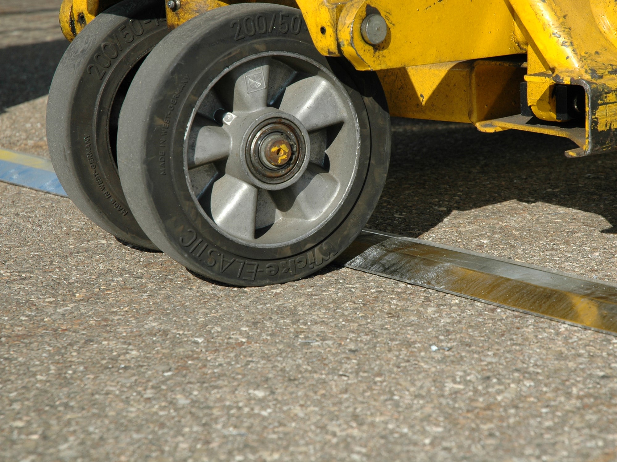 Bodenschwelle eines Gasflaschenlagers befahren mit einem gelben Hubwagen