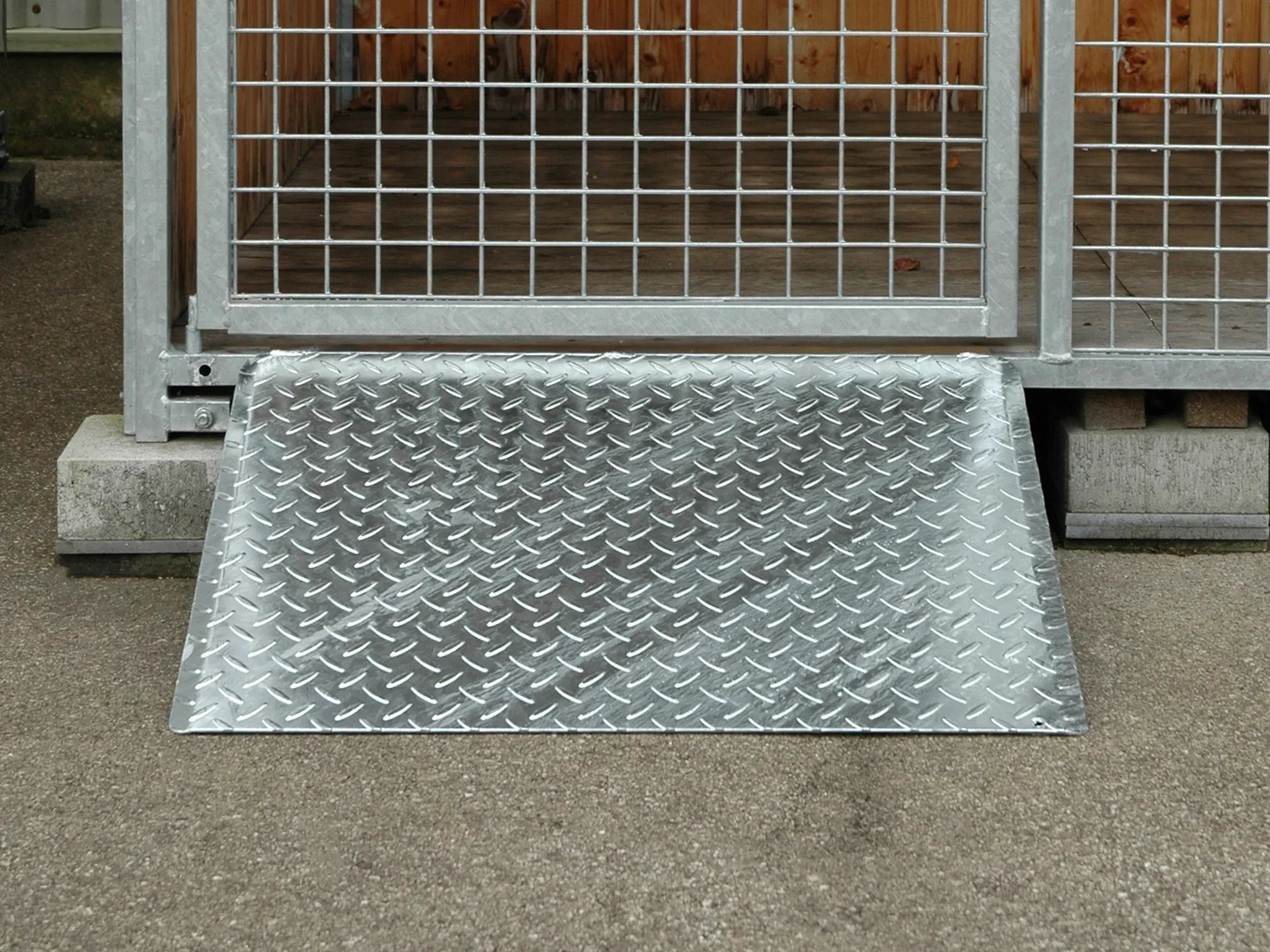 Rampe für Schubkarren eingehängt in einem Türrahmen für Brennholzlager