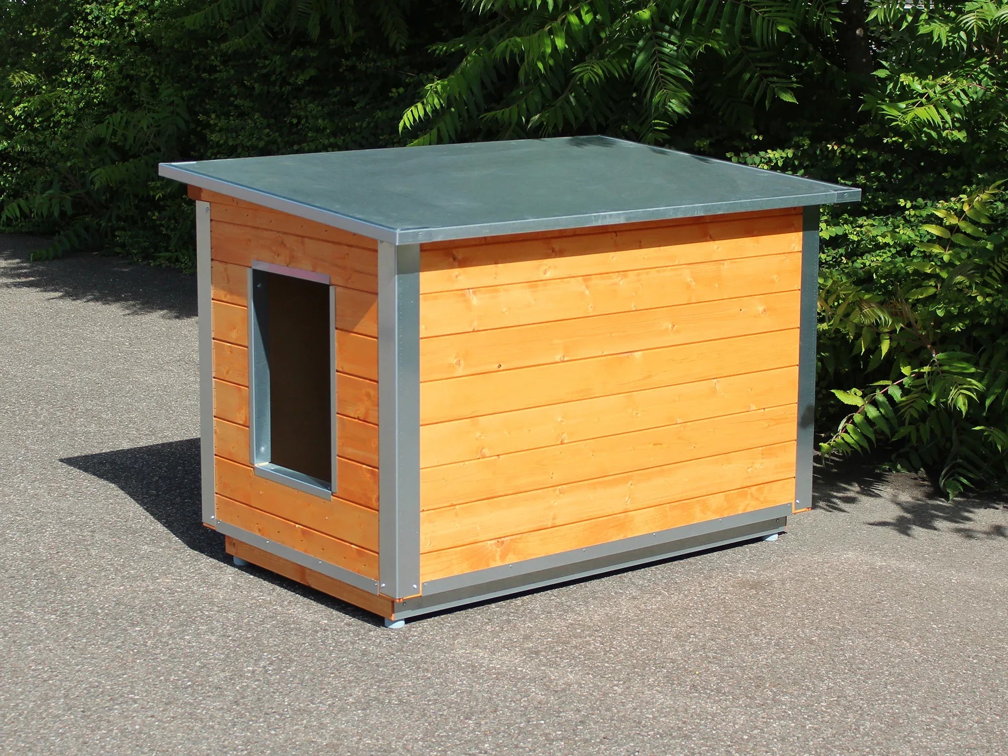 Hundehütte aus Holz mit Blechdach aufgestellt im Freien