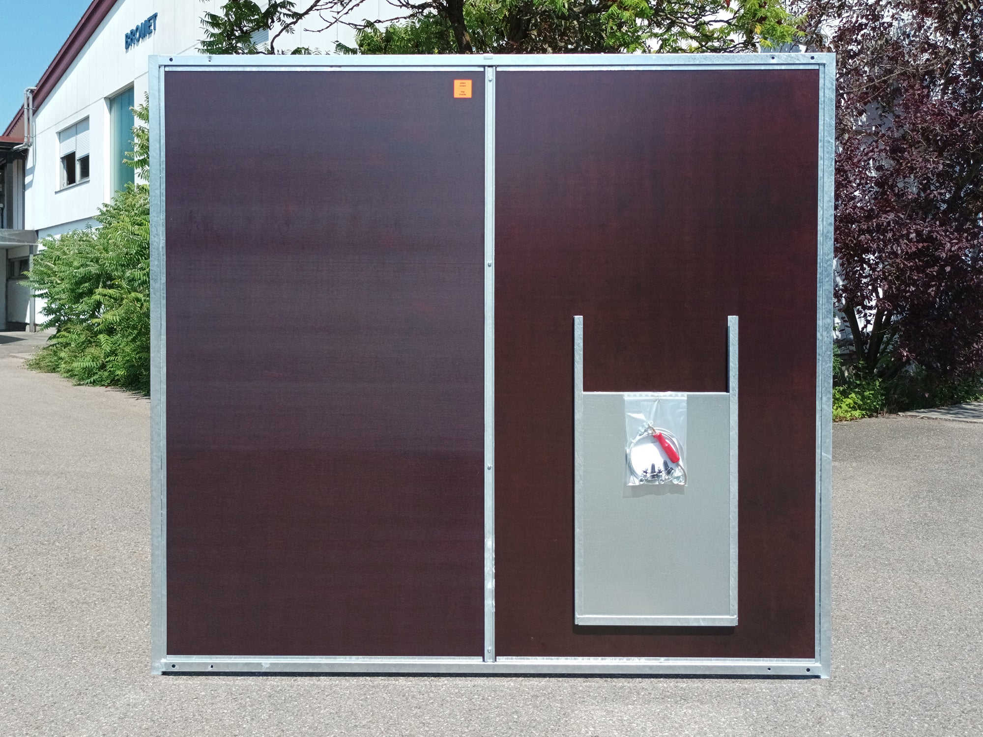 Hundezwingerwand aus braunen Mehrschichtplatten mit Durchgang für Hunde