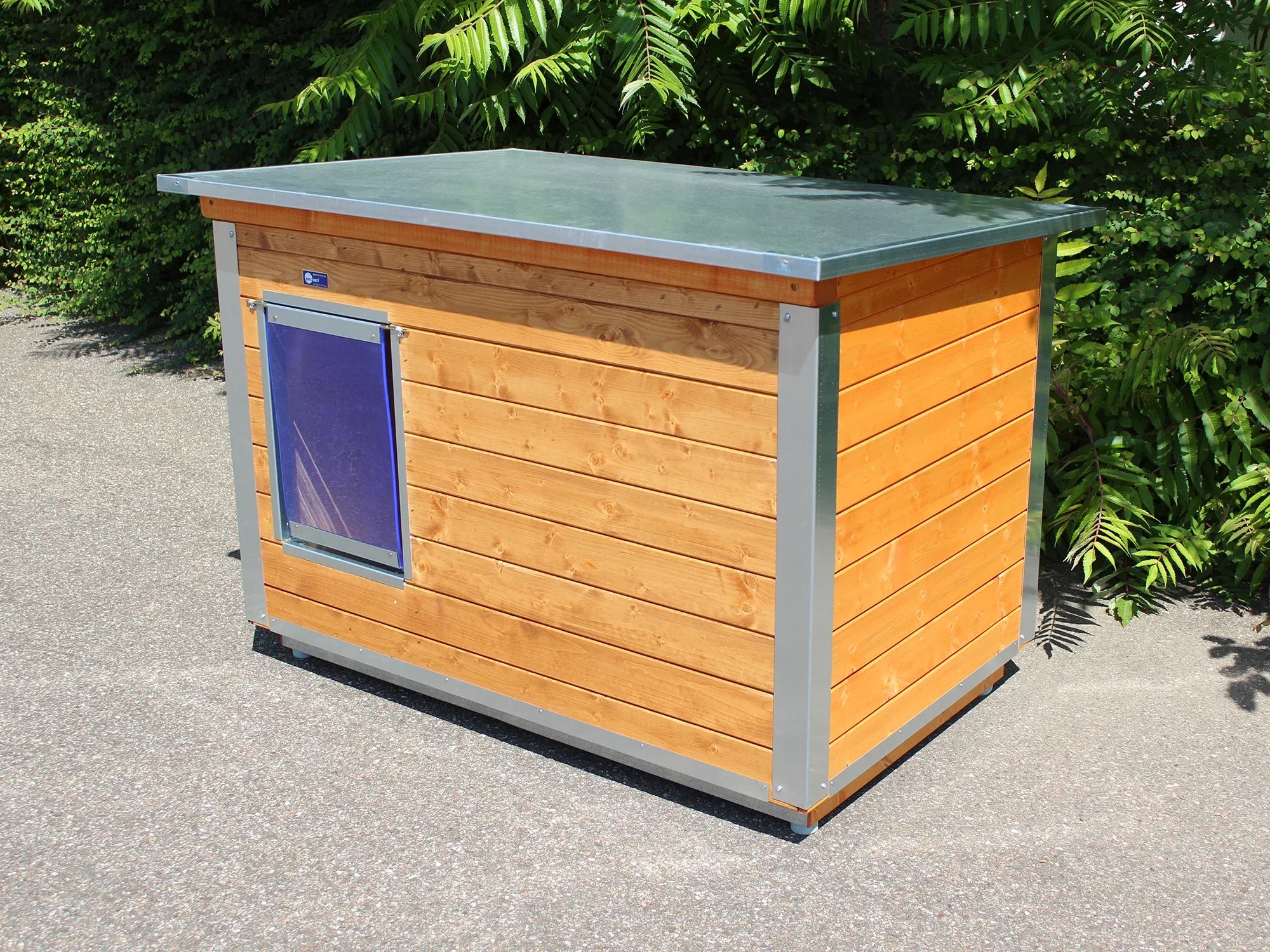 Hundehütte mit gestrichenen Außenwänden und einem Eingang mit Pendelklappe