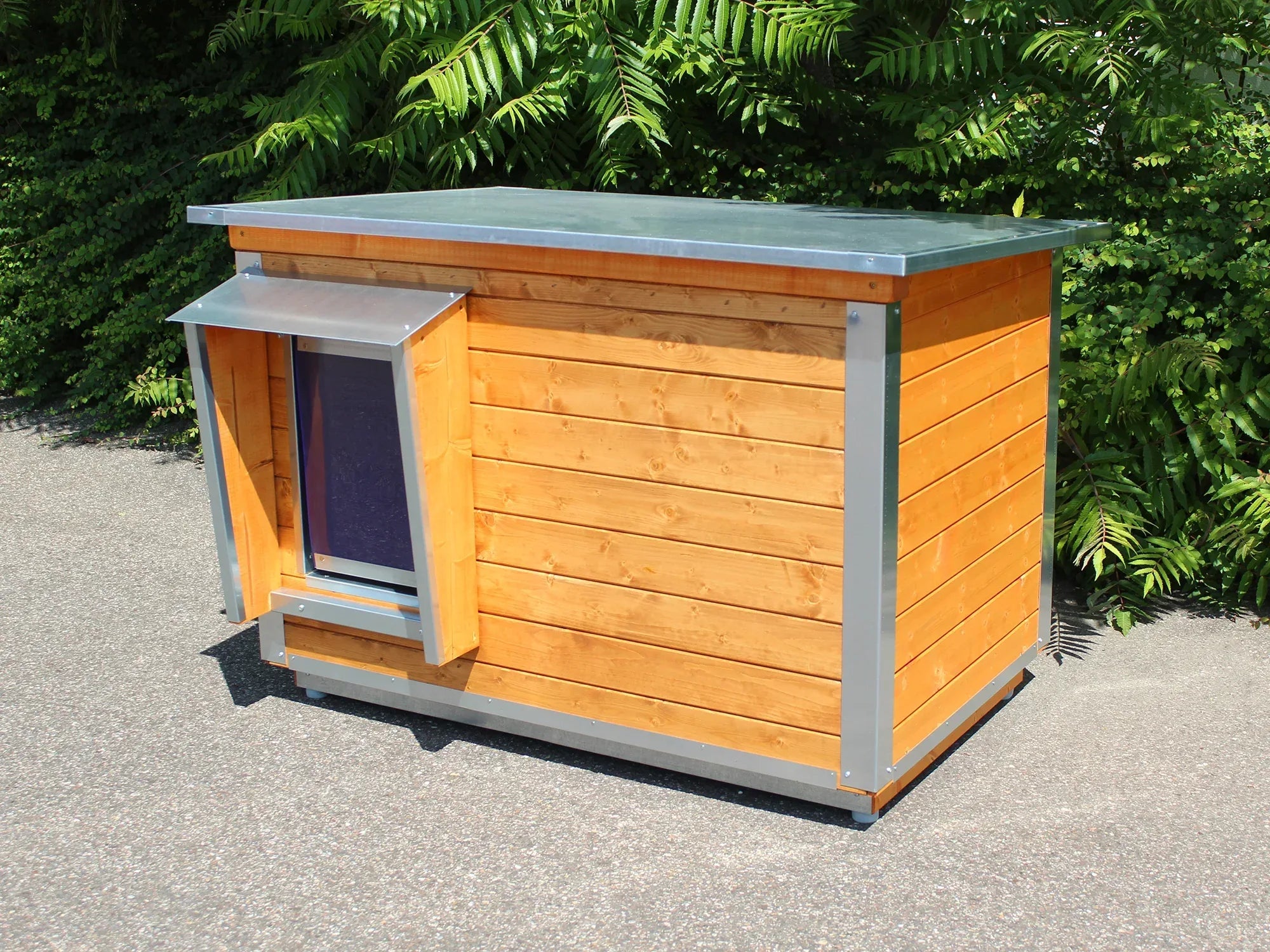 Hundehütte mit Blechdach und geschütztem Einstieg für Hunde im Außenbereich
