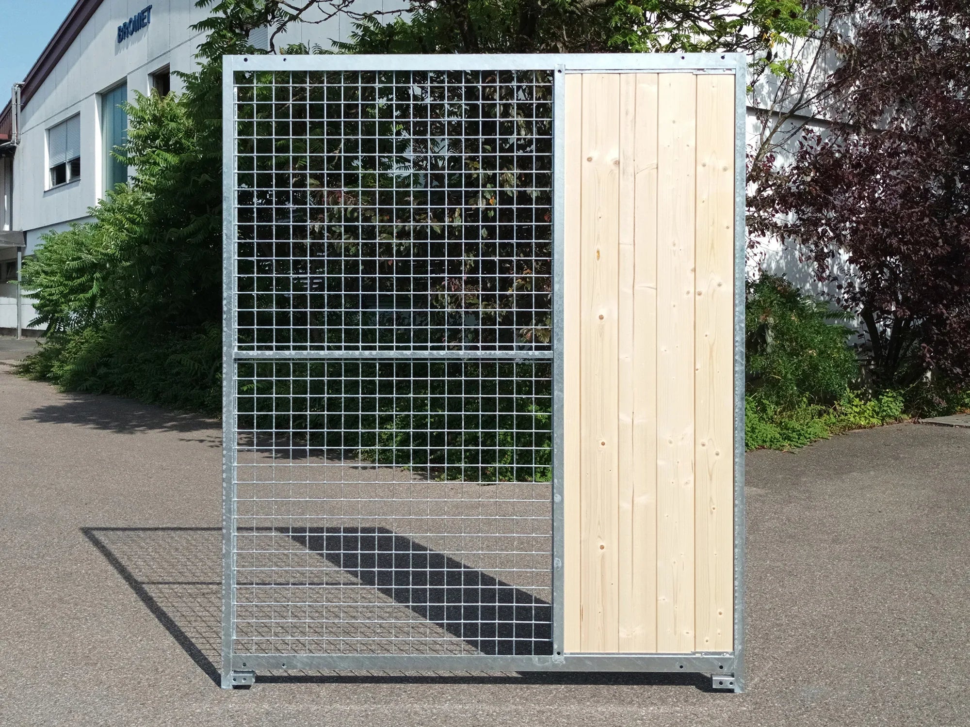 Gitterelement aus verzinktem Stahl mit Windschutz aus hellem Fichtenholz auf der rechten Seite