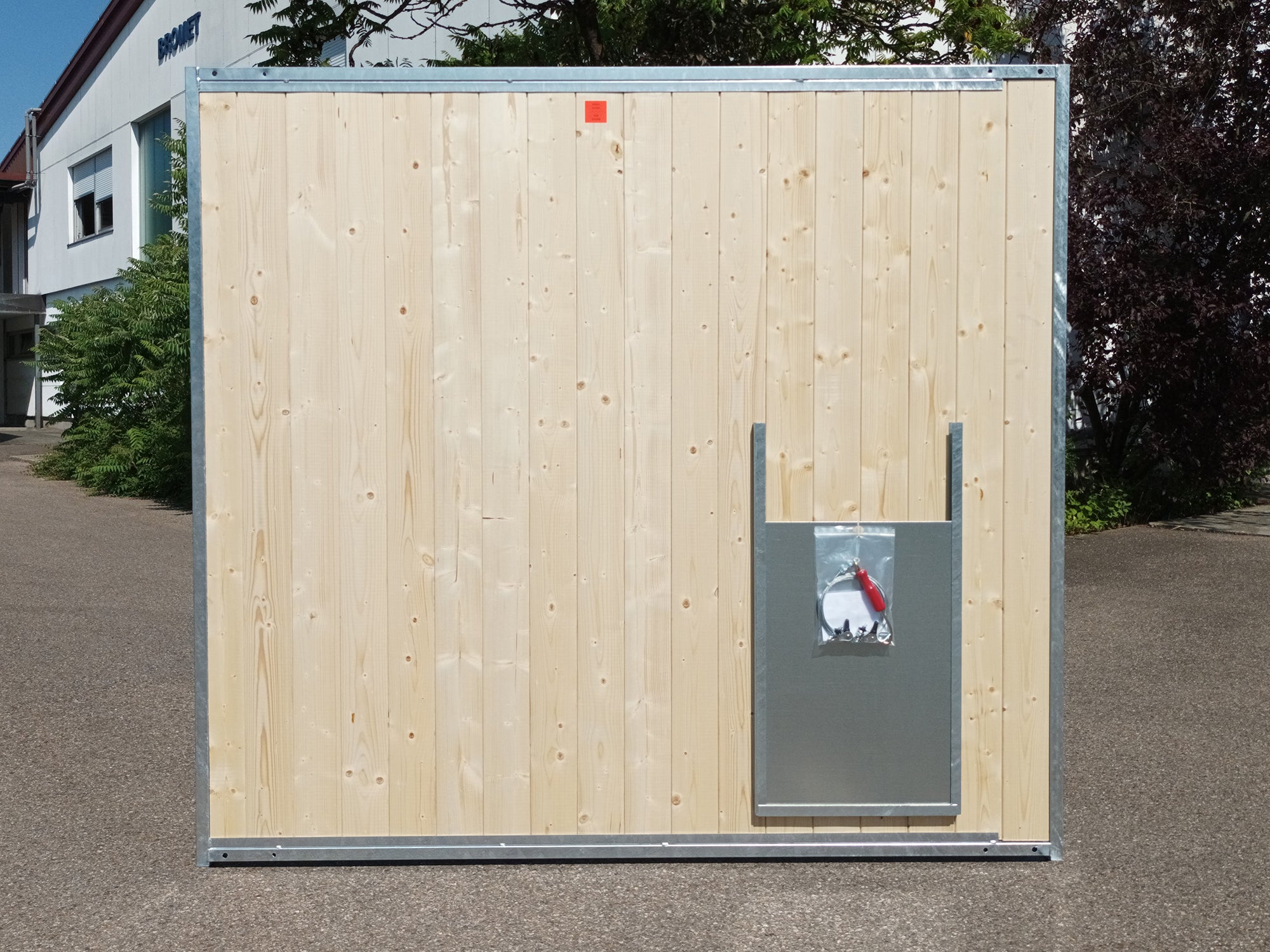 Hundezwingerwand aus Holz mit Stahlrohrrahmen und einem Hundedurchlass