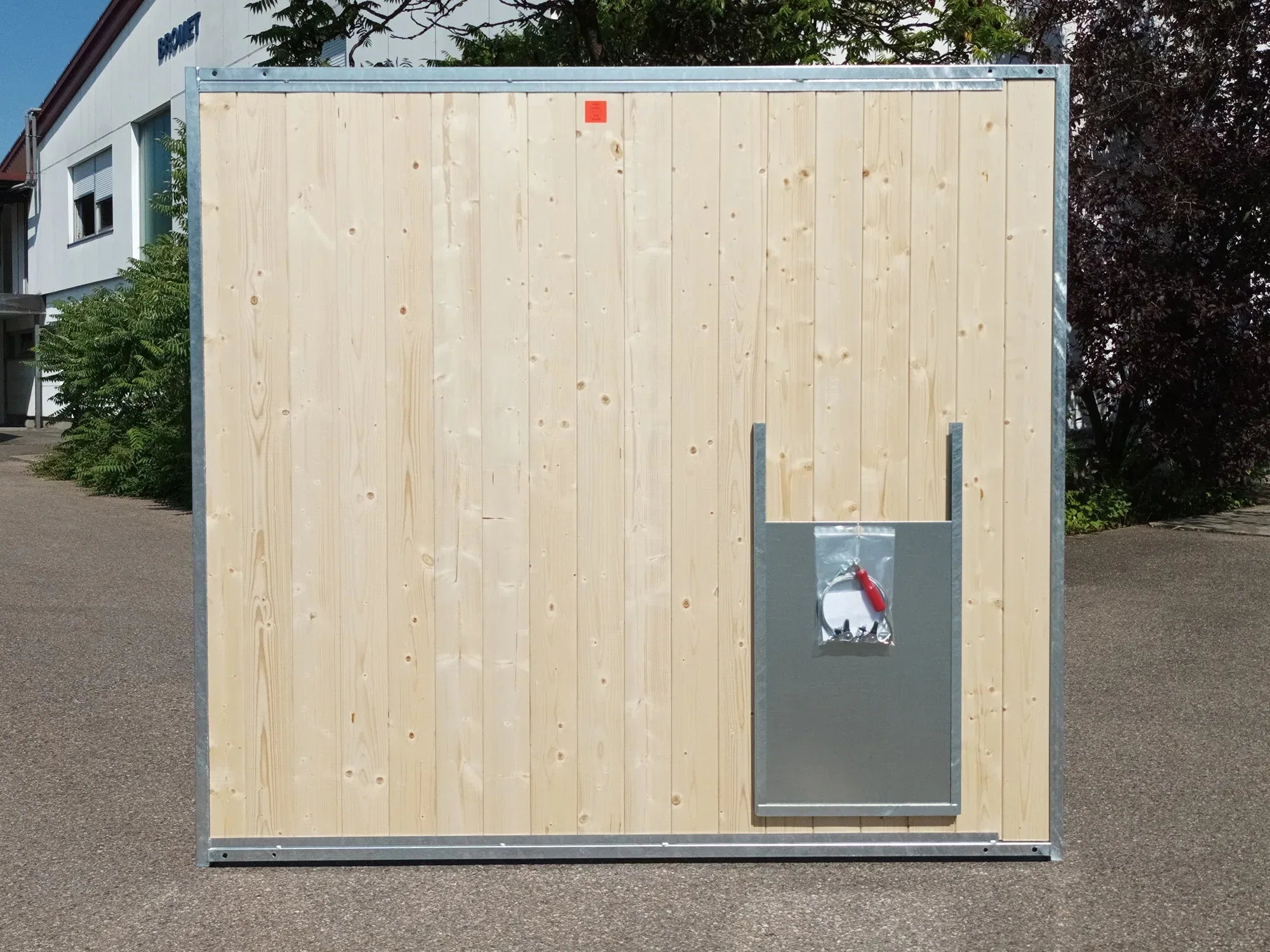 Hundezwingerwand aus Holz mit Stahlrohrrahmen und einem Hundedurchlass