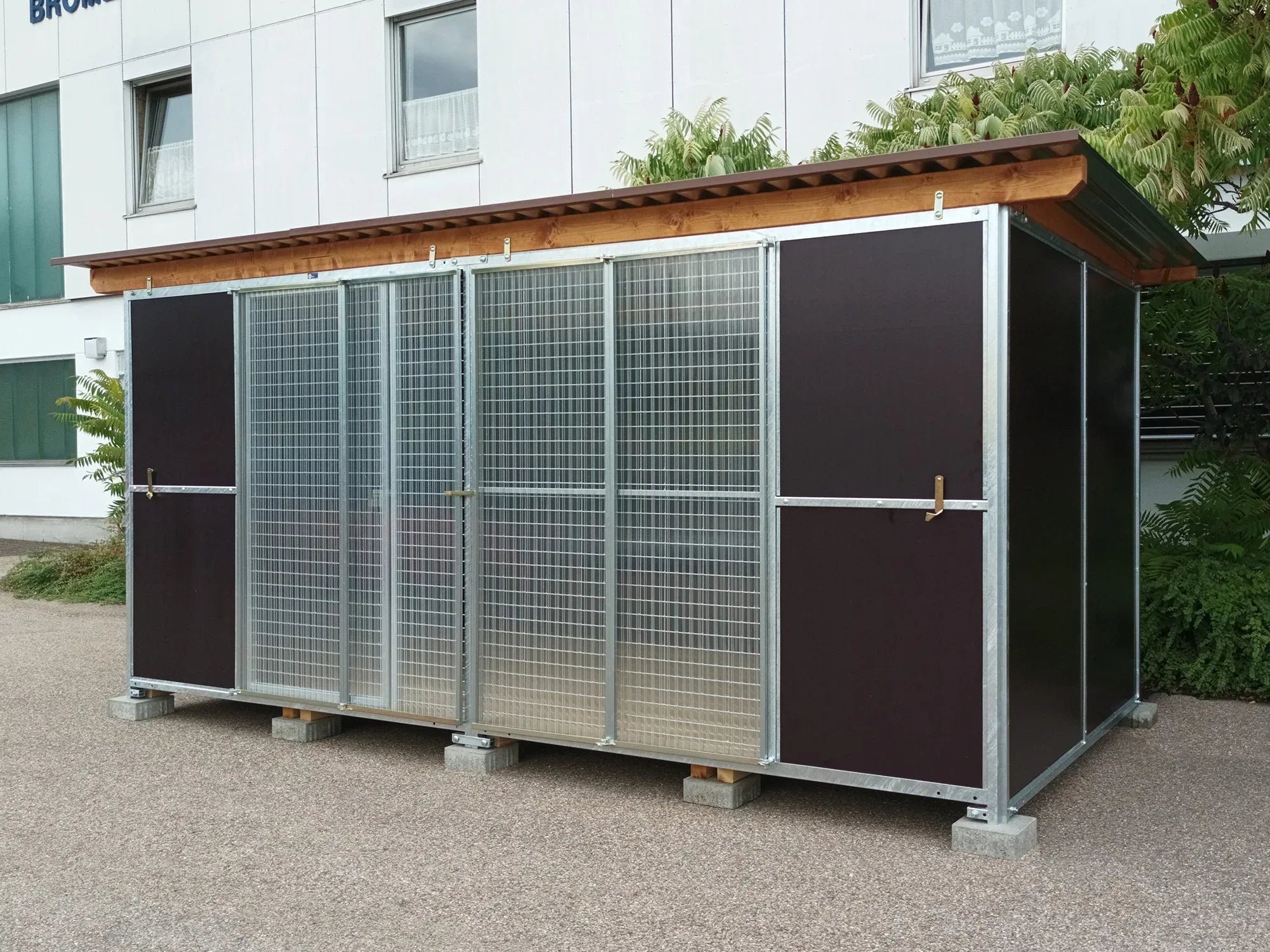 Hundezwinger mit Wänden aus robusten Mehrschichtplatten und verschlossenen Schutzscheiben
