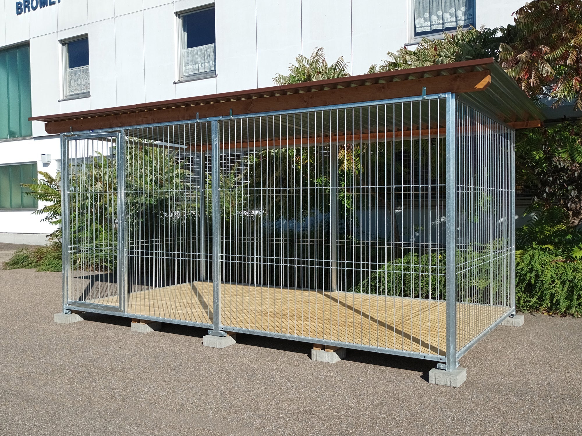 Stahlzwinger für Hunde mit robusten Rohrstabwänden und einem Boden aus Fichtenbretter