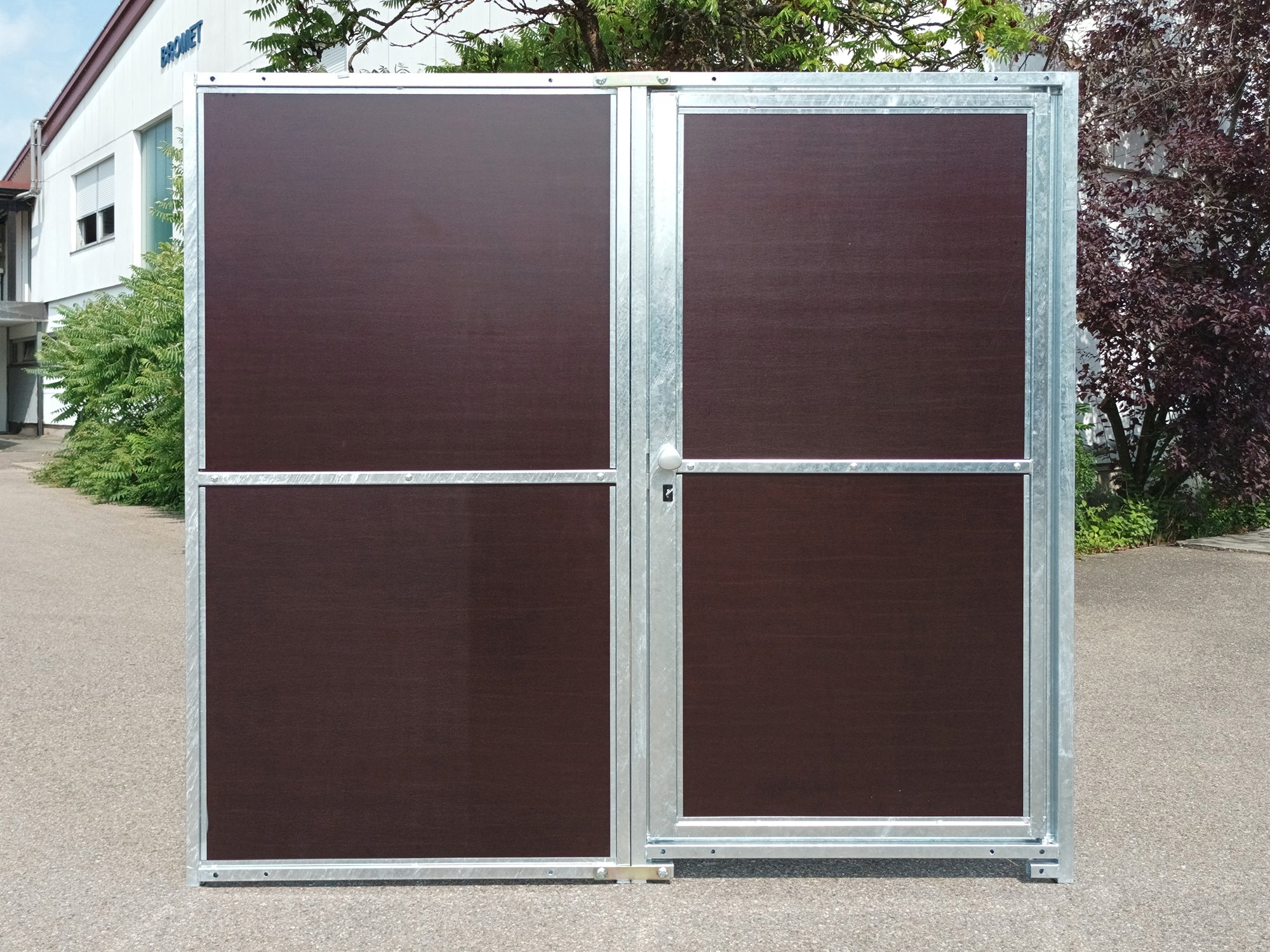 Schutzwand aus Mehrschichtplatten und Stahlrahmen mit abschließbarer Türe