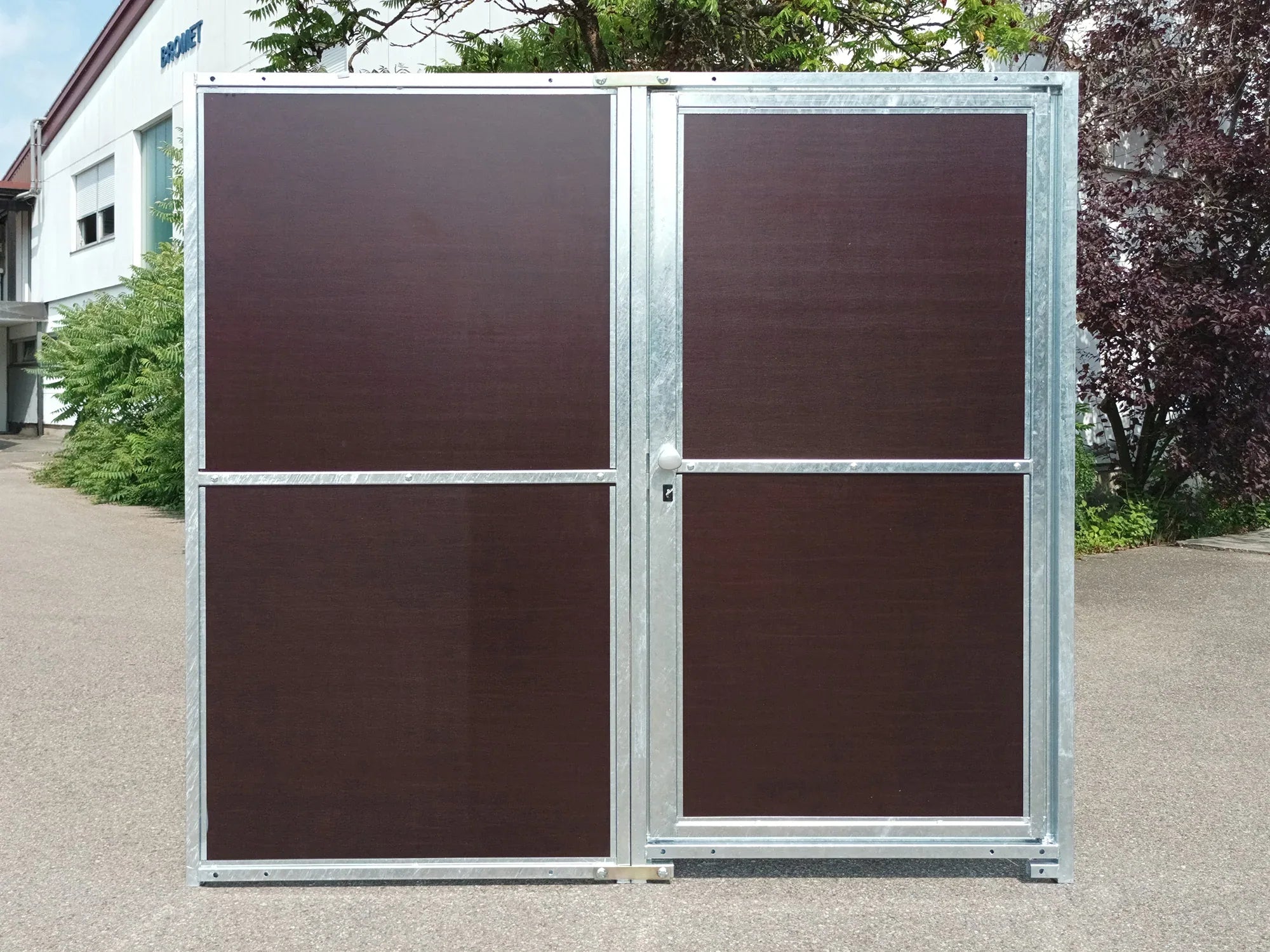 Schutzwand aus Mehrschichtplatten und Stahlrahmen mit abschließbarer Türe