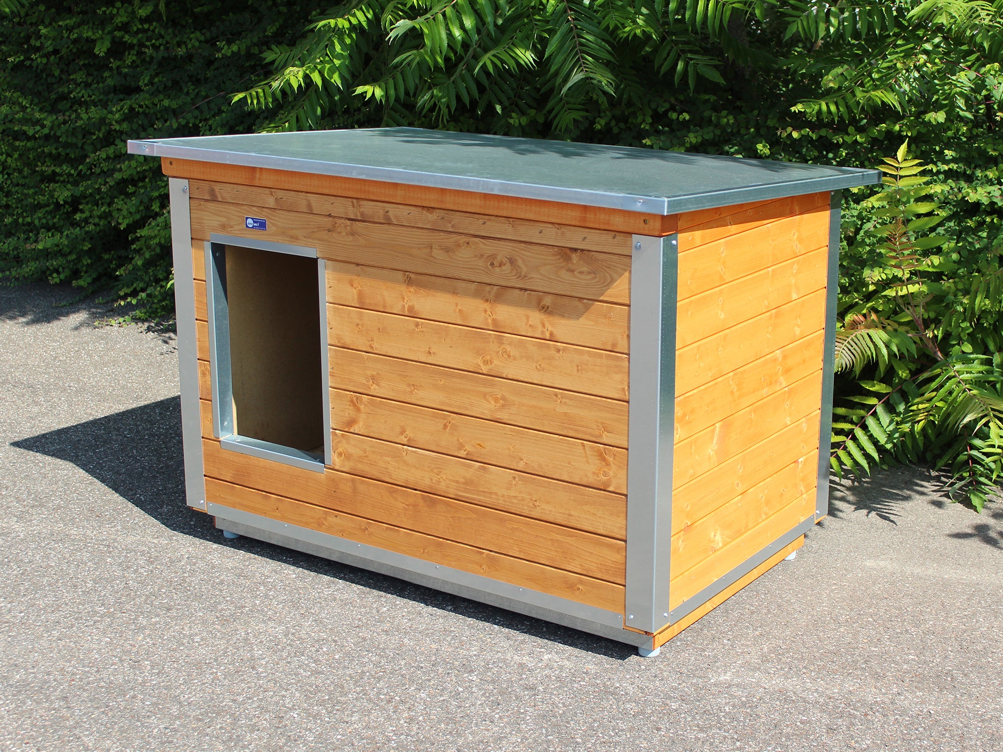 Hundehütte mit Eingang auf der Seite mit robustem Dach aufgebaut im Garten