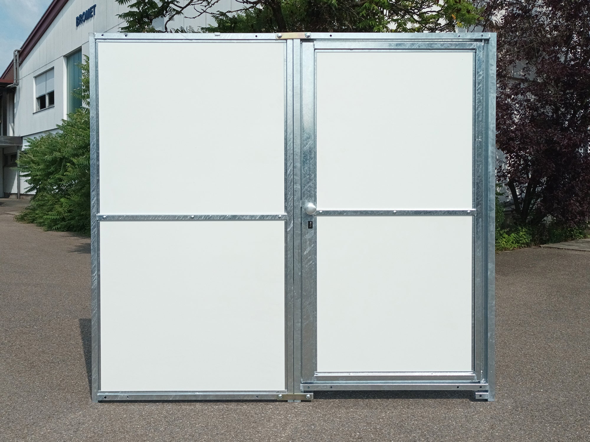 Weiße Hundezwingerwand mit absperrbarer Türe nach außen öffnend