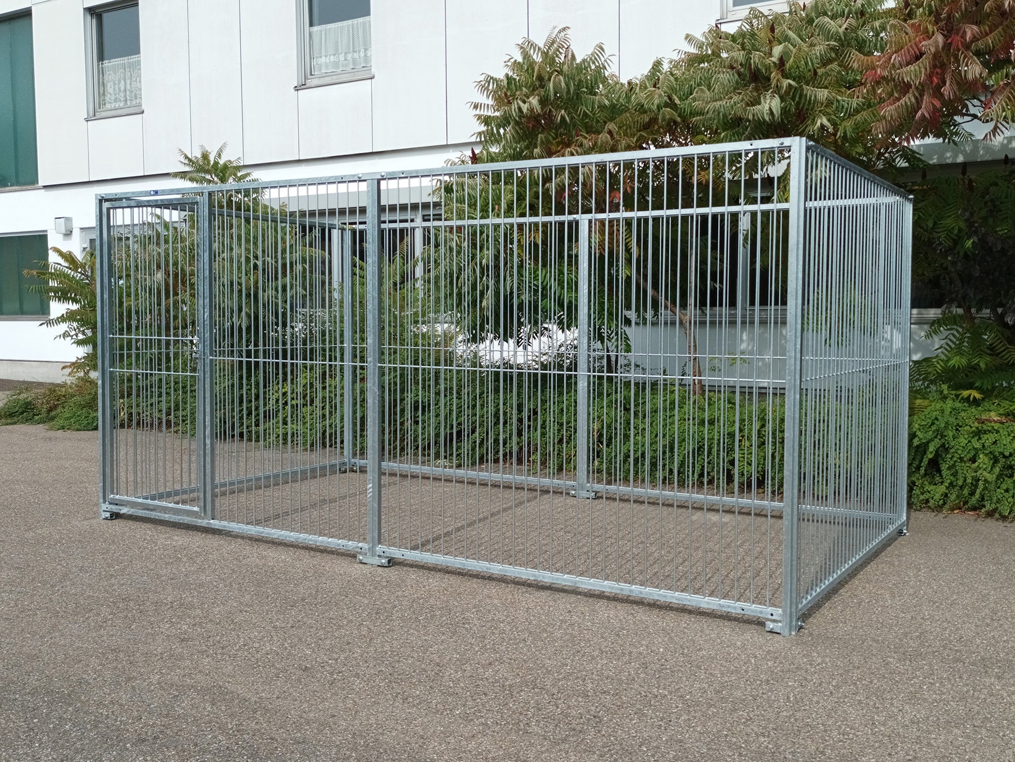 Stahlzwinger für Hunde aufgebaut im Freien mit abschließbarer Türe