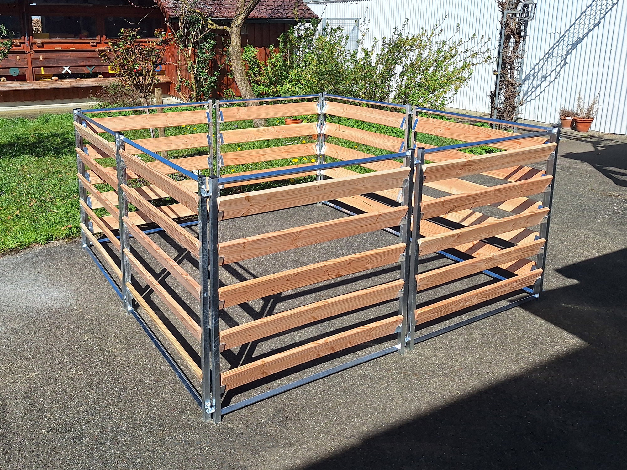 Komposter mit verzinktem Metallrahmen und Holzbrettern aus Douglasie, aufgebaut im Garten