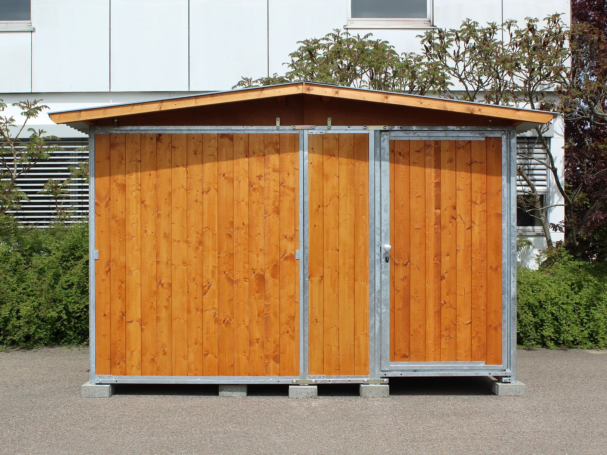Gerätehaus aufgebaut im Garten mit Holzwänden und Blechdach